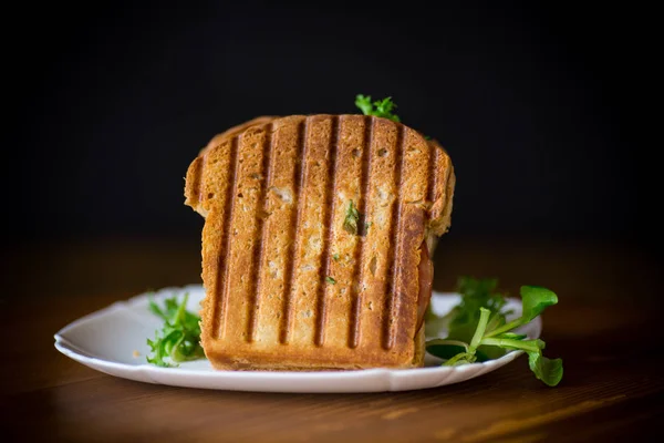 Doppio panino caldo con foglie di lattuga e farcito in un piatto — Foto Stock