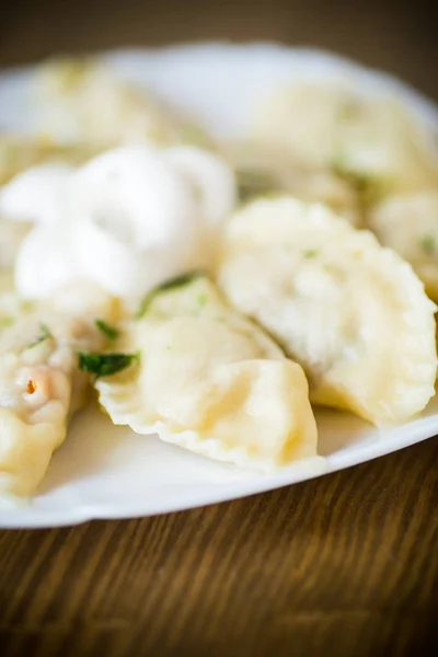 Kokt dumplings med fyllning på ett träbord — Stockfoto