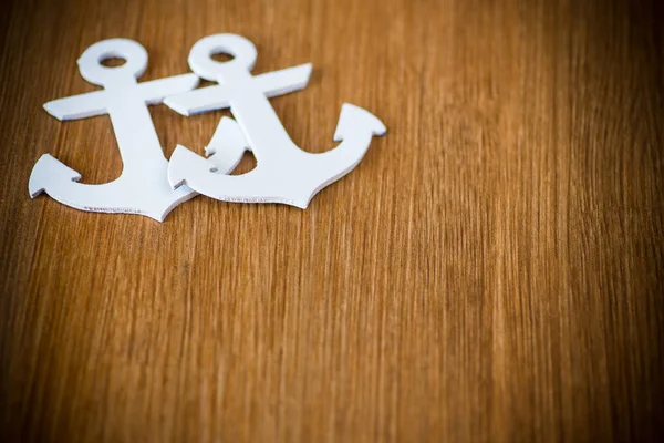 White decorative anchor on a wooden background — Stock Photo, Image