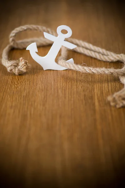 White decorative anchor on a wooden background — Stock Photo, Image