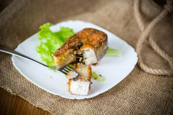 Piece of fried pike fish in a plate on a wooden — Stock Photo, Image