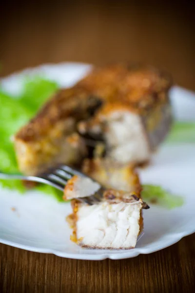 Parte de peixe de lúcio frito em uma chapa em uma madeira — Fotografia de Stock