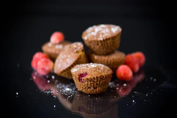Свежие сладкие кексы с ягодами внутри на черном — стоковое фото