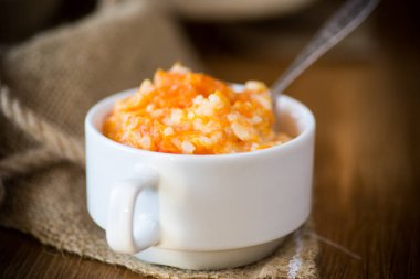 ahşap bir masa bir tabağa pilav ile tatlı haşlanmış kabak püresi