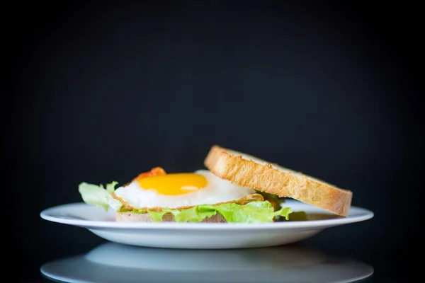 新鲜的三明治与生菜叶和煎蛋与热烤面包 在黑色的背景 — 图库照片