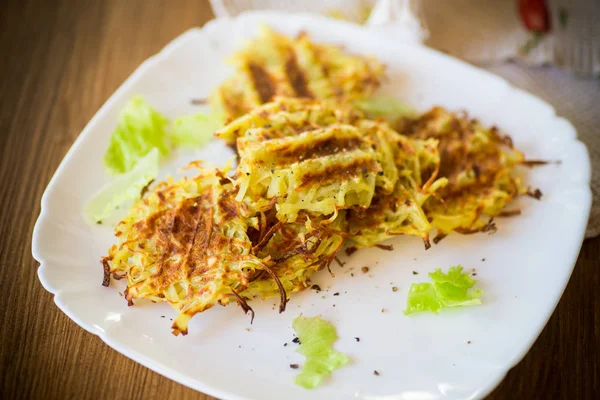 Grilled potato pancakes in a plate, on a wooden table — Stock Photo, Image