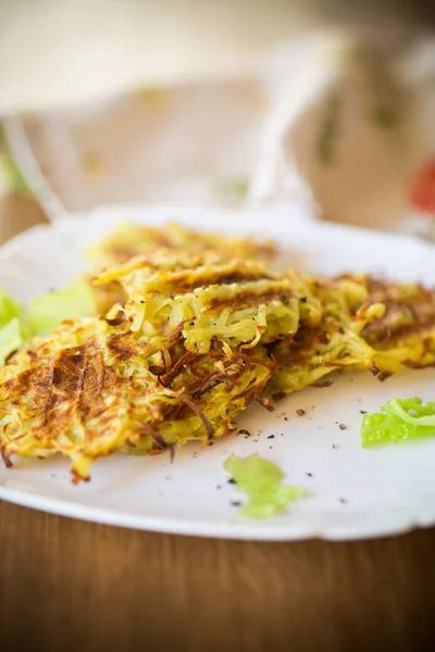 Gegrilde aardappel pannenkoeken in een plaat, op een houten tafel — Stockfoto