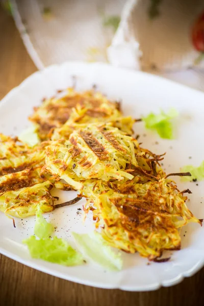 Grilled potato pancakes in a plate, on a wooden table — Stock Photo, Image