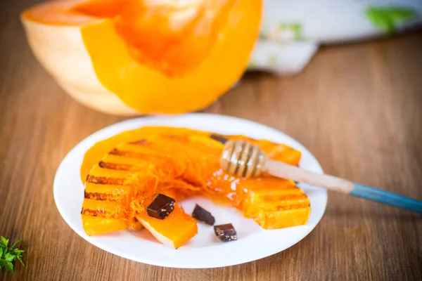 Gegrilde zoete rijpe pompoen, in een bord met honing — Stockfoto