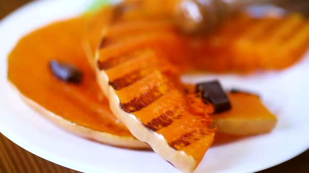 Calabaza madura dulce a la parrilla, en un plato con miel — Vídeos de Stock