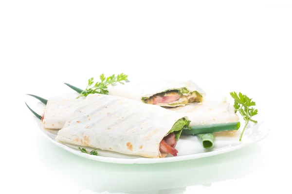 Rollo de pita con hojas de lechuga, verduras y salchichas en un plato — Foto de Stock