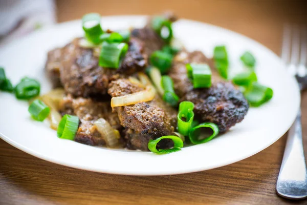 Fried liver with onions in a plate on a wooden — Stock Photo, Image