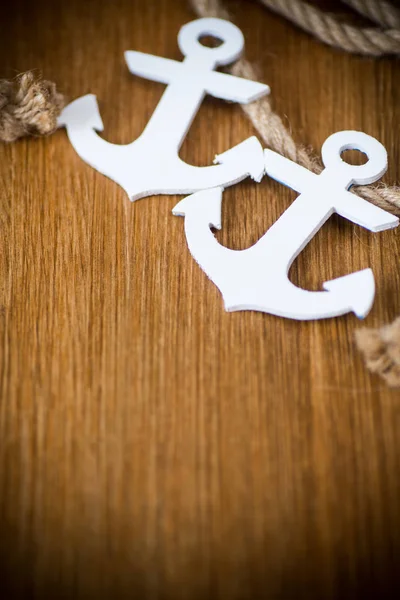 White decorative anchor on a wooden background — Stock Photo, Image