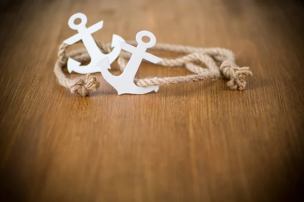 White decorative anchor on a wooden background — Stock Photo, Image
