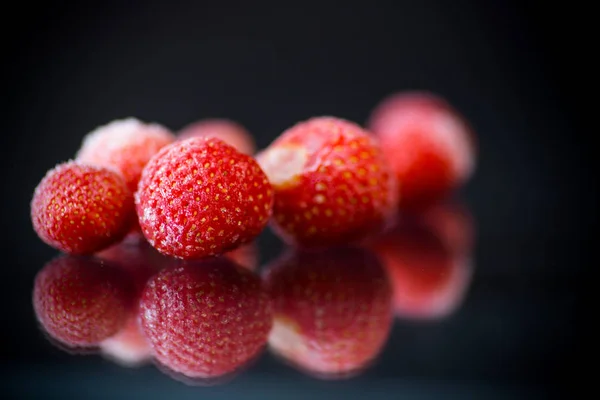 Fresh frozen red ripe strawberries on a black — Stock Photo, Image