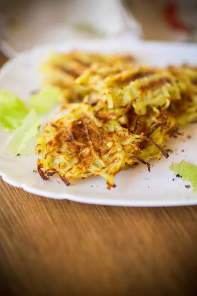 Tortitas de patata a la parrilla en un plato, sobre una mesa de madera — Foto de Stock