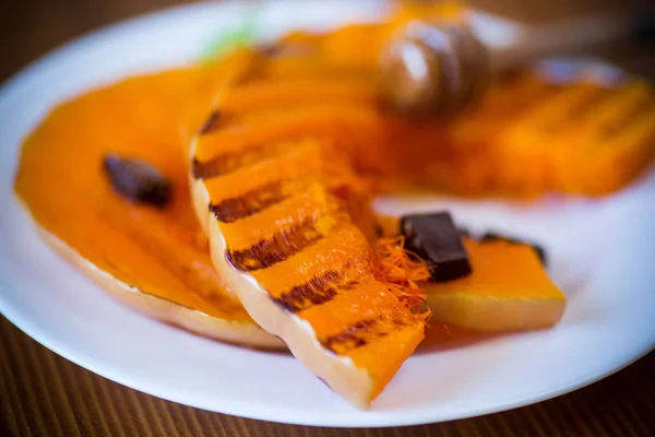 Gegrilde zoete rijpe pompoen, in een bord met honing — Stockfoto