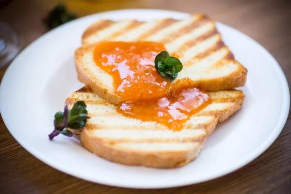 Pane tostato fritto con marmellata di albicocche in un piatto — Foto Stock