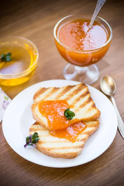 Stekt rostat bröd med aprikos marmelad på en tallrik — Stockfoto