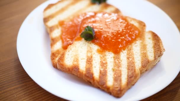 Pain grillé avec confiture d'abricot dans une assiette — Video