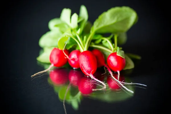 Świeże organiczne czerwone rzodkiewki na czarnym tle — Zdjęcie stockowe