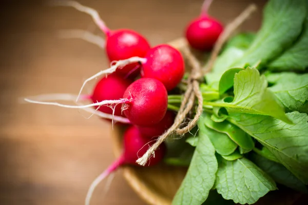 Świeże organiczne czerwone rzodkiewki na drewnianym stole — Zdjęcie stockowe