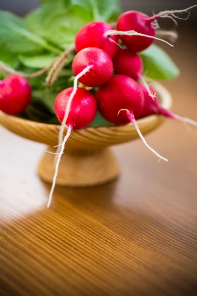 Świeże organiczne czerwone rzodkiewki na drewnianym stole — Zdjęcie stockowe