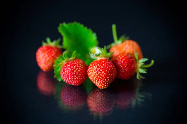 Rijp rode aardbeien op een zwarte achtergrond — Stockfoto