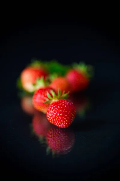 Reife rote Erdbeeren auf schwarzem Hintergrund — Stockfoto