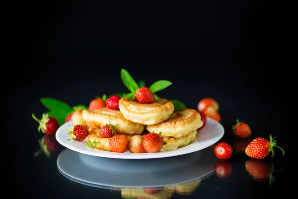 Stekt söta pannkakor med mogna jordgubbar i en tallrik — Stockfoto