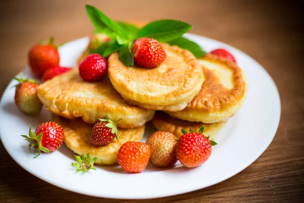 Fried sweet pancakes with ripe strawberries in a plate — Stock Photo, Image