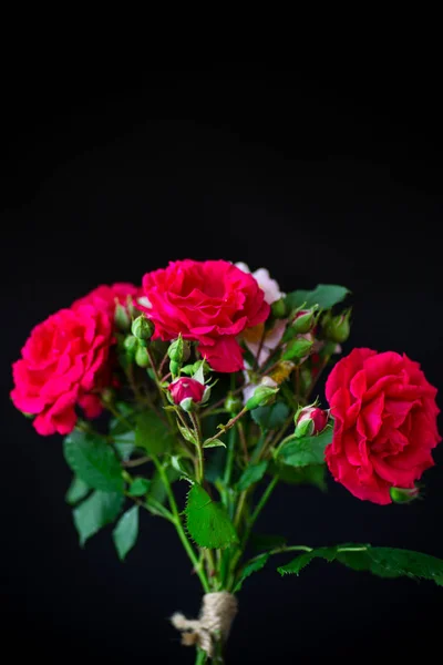 Ramo de hermosas rosas rojas sobre un negro — Foto de Stock