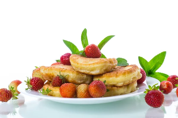 Fried sweet pancakes with ripe strawberries in a plate — Stock Photo, Image