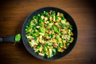 kabak ahşap bir masa üzerinde bir tavada soğan ve otlar ile kızartılmış