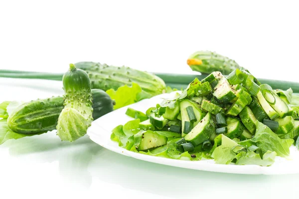 Insalata fresca di cetrioli e verdure in un piatto isolato su bianco — Foto Stock