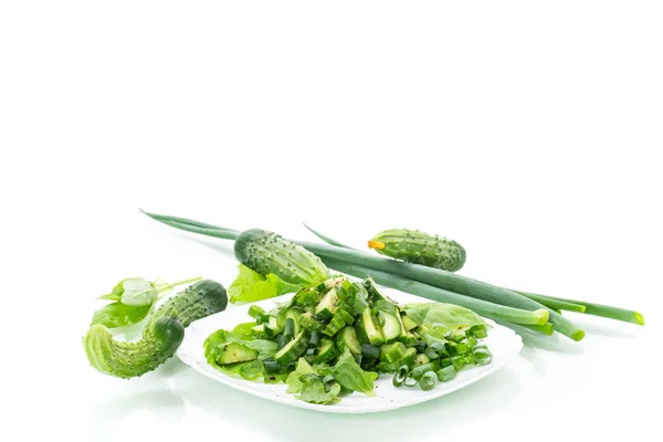 Fresh salad of cucumbers and greens in a plate isolated on white — Stock Photo, Image