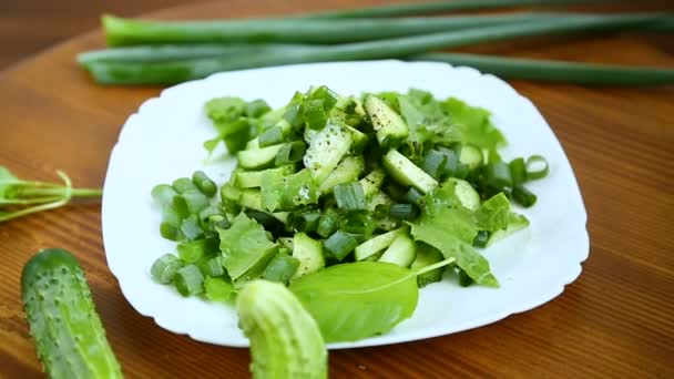 Insalata fresca di cetrioli e verdi in un piatto su un legno — Video Stock