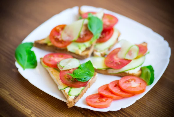 Sanduíche saboroso com pasta de coalhada, pepinos frescos e tomates — Fotografia de Stock