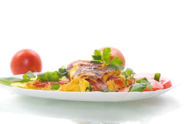 Gebakken omelet van zelfgemaakte biologische eieren met tomaten en groene uien Stockfoto