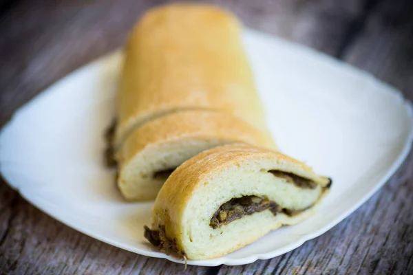 Baked yeast dough roll with fried mushrooms in a plate — Stock Photo, Image