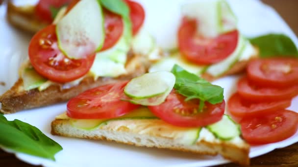 Smakelijke sandwich met wrongel pasta, verse komkommers en tomaten — Stockvideo