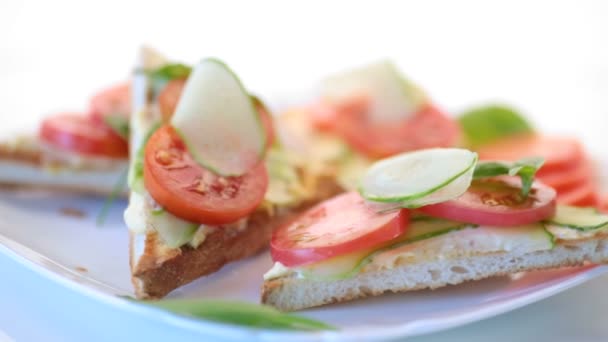 Sabroso sándwich con pasta de cuajada, pepinos frescos y tomates — Vídeo de stock