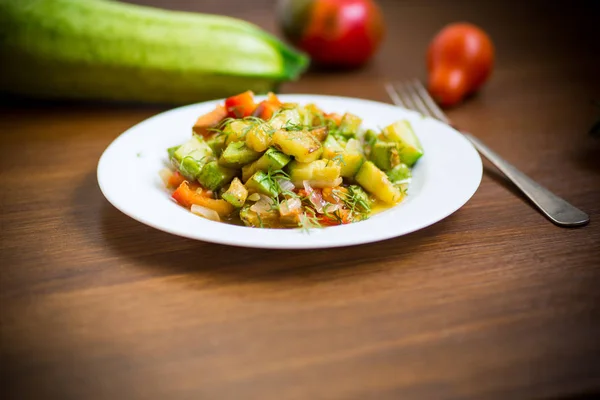 Calabacín frito con pimiento rojo, cebollas, tomates y otras verduras Imagen De Stock