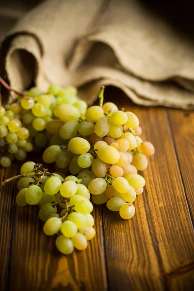 Bouquet de raisins verts sur une table en bois sombre — Photo