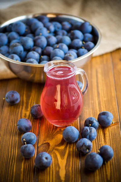 Sweet compote of autumn blue plums in a glass decanter — Stock Photo, Image