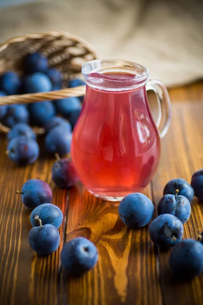 Sweet kompott av höst blå plommon i ett glas dekanter — Stockfoto