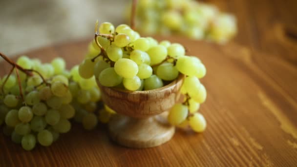 Racimo de uvas verdes sobre una mesa de madera oscura — Vídeos de Stock