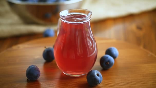 Zoete compote van herfst blauwe pruimen in een glazen karaf — Stockvideo