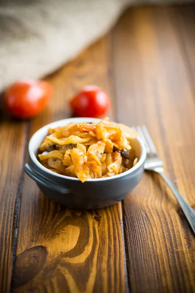 Stewed cabbage on the old wooden background — Stock Photo, Image