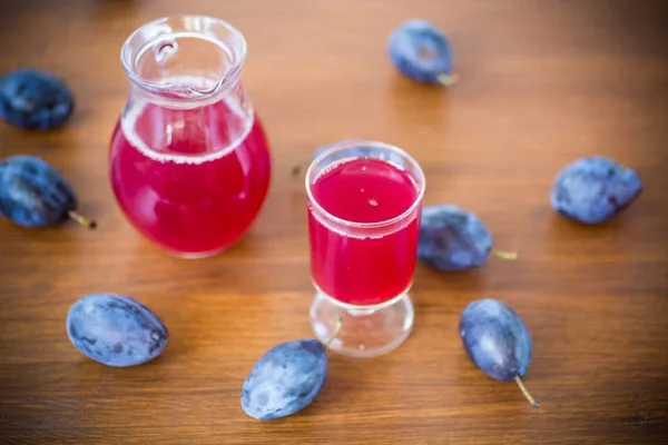 Compote van herfst blauwe pruimen op een houten tafel. — Stockfoto